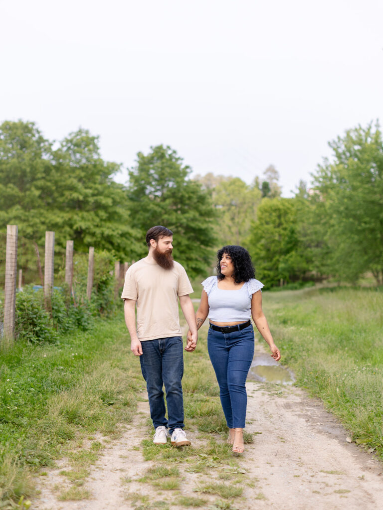 Walking hand-in-hand through a sun-drenched field at Normanskill Farm in Albany, NY