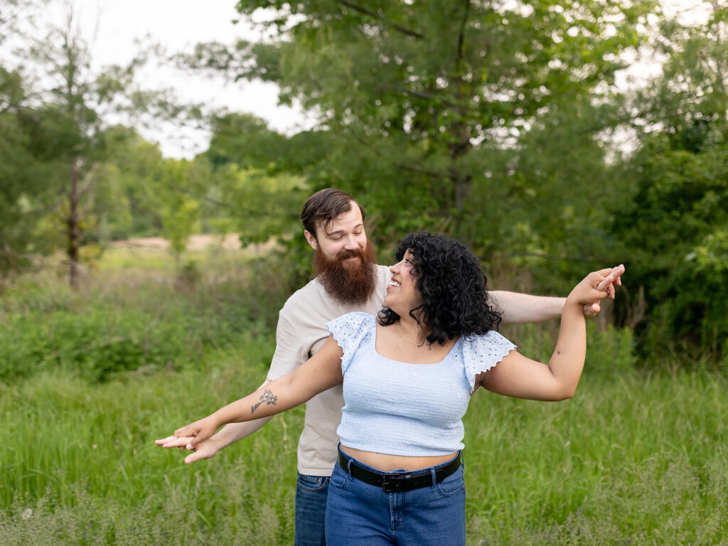 Couple playing airplane in a field