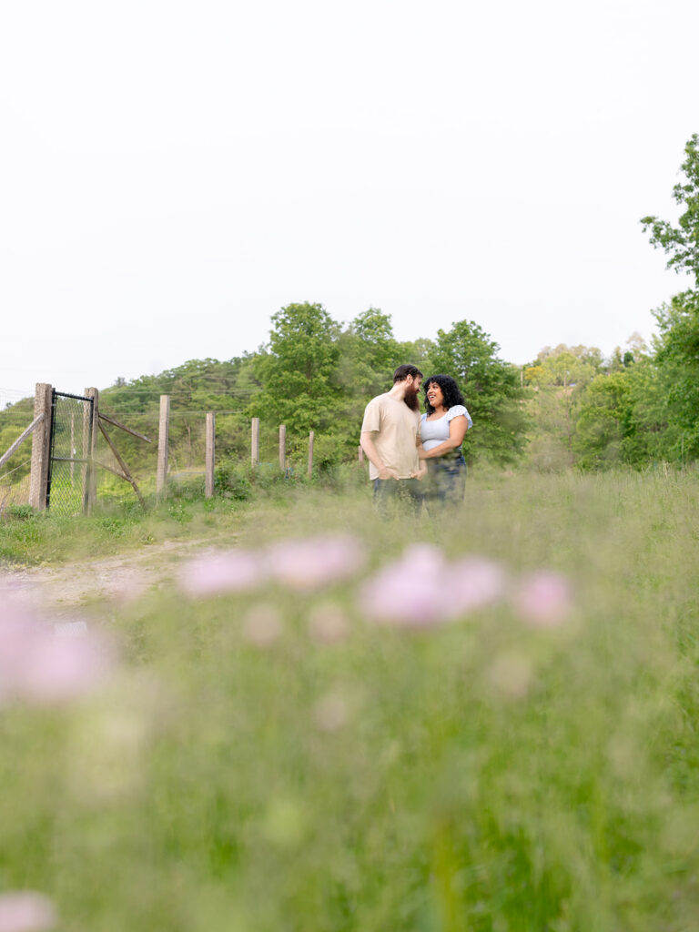 Couple far away in a field of wild flowers