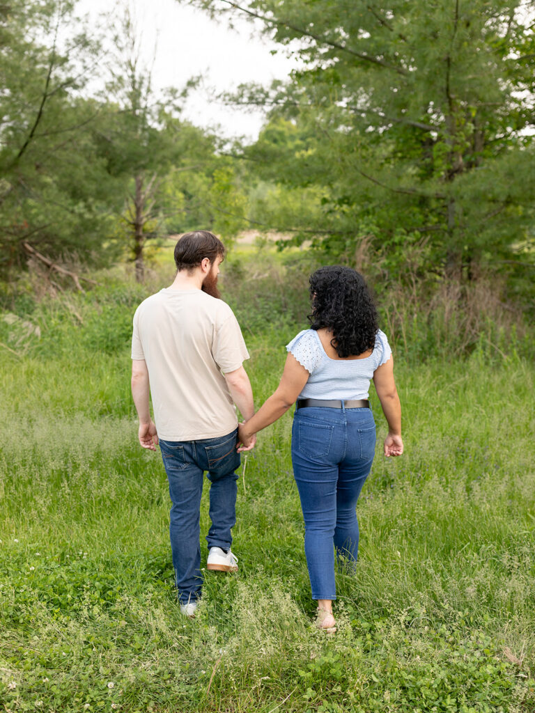 Couple walking away in a green field