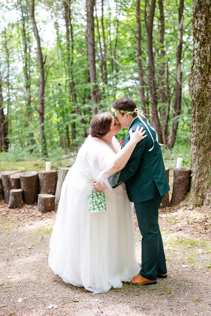 Newlyweds kissing in the woods