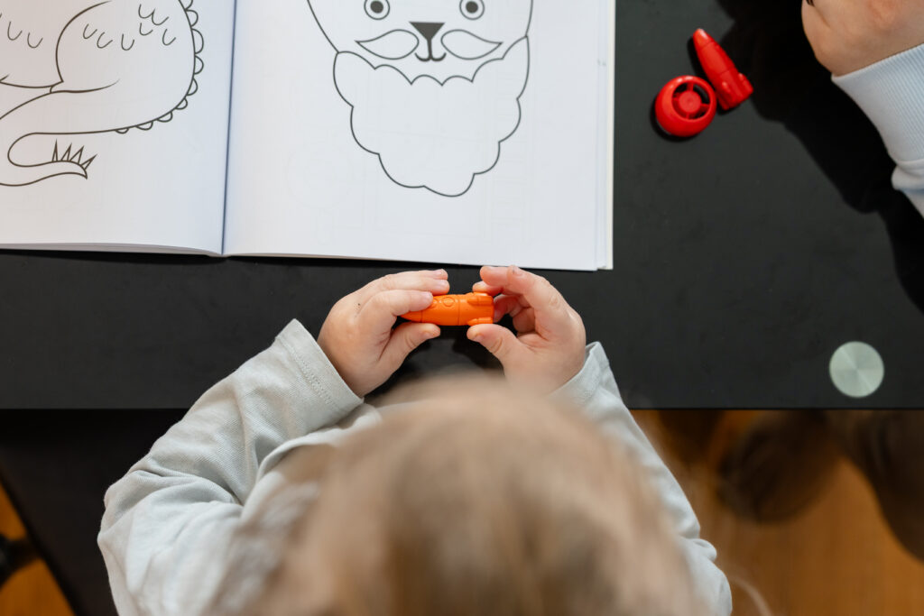 Child playing with rocket ship crayons