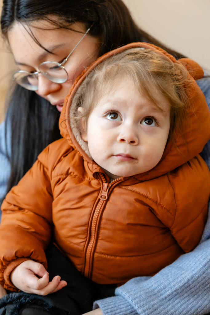 Mother dressing child in winter clothing 
