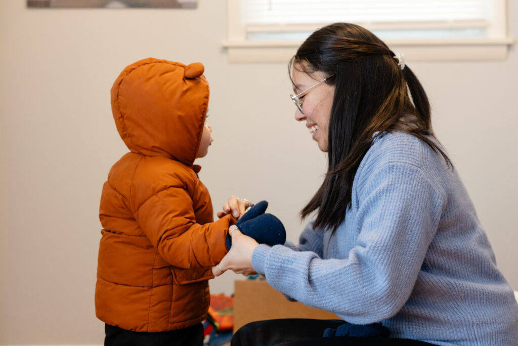 Mother putting on child's gloves