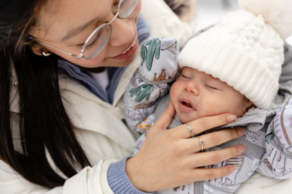 Mother holding baby outside in the snow